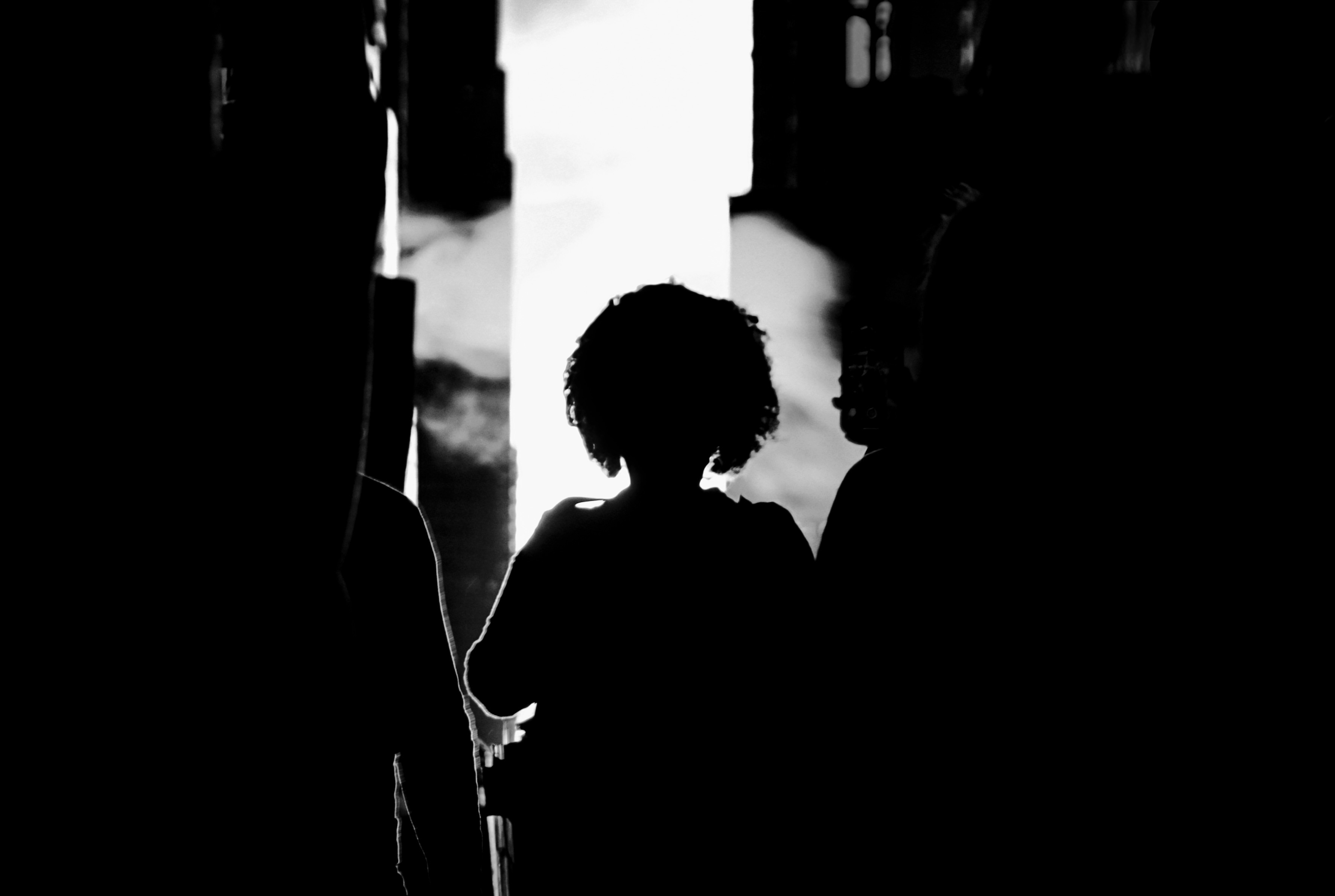 Silhouetted people framed by a bright doorway